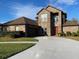 Two story brick home with a well-manicured lawn, a two car garage, and a curved driveway at 2355 Abalone Blvd, Orlando, FL 32833