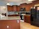Bright kitchen with black appliances, granite counters, tiled floor, and dark wood cabinetry at 2355 Abalone Blvd, Orlando, FL 32833