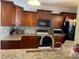 Well-lit kitchen featuring granite countertops, stainless appliances and dark wood cabinetry at 2355 Abalone Blvd, Orlando, FL 32833