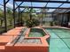 Screened in pool area with an attached spa and tropical landscaping at 2355 Abalone Blvd, Orlando, FL 32833