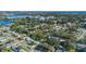 Aerial view of a residential area featuring houses, lush trees, and a lake in the distance at 5533 Satel Dr, Orlando, FL 32810