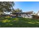 Home's back with pergola, patio furniture, and grassy yard at 5533 Satel Dr, Orlando, FL 32810