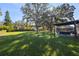 Spacious backyard with lush lawn, large shade tree, and patio area at 5533 Satel Dr, Orlando, FL 32810