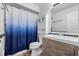 Clean bathroom with white vanity and blue shower curtain at 5533 Satel Dr, Orlando, FL 32810