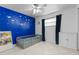 bedroom with blue walls, twin bed, and built-in shelves at 5533 Satel Dr, Orlando, FL 32810