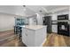 Modern kitchen with white cabinets, stainless steel appliances, and island at 5533 Satel Dr, Orlando, FL 32810