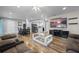Bright living room with hardwood floors, large TV, and comfortable seating at 5533 Satel Dr, Orlando, FL 32810