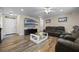Spacious living area featuring wood-look floors and a large TV at 5533 Satel Dr, Orlando, FL 32810