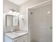 This bathroom offers a granite sink, vanity, a square mirror, and a tiled walk-in shower at 632 Oakhurst St, Altamonte Springs, FL 32701