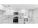 Bright kitchen featuring stainless appliances, white cabinets, granite counters and tile backsplash at 632 Oakhurst St, Altamonte Springs, FL 32701