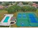 Aerial view of community amenities, including a sparkling pool, tennis courts, and a basketball court for active recreation at 10157 Spring Lake Dr, Clermont, FL 34711