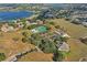 Aerial view of a residential area with tennis courts, swimming pool, and serene lake views at 10157 Spring Lake Dr, Clermont, FL 34711