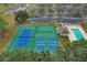 Aerial view of community amenities, including a sparkling pool, tennis courts, and a basketball court for active recreation at 10157 Spring Lake Dr, Clermont, FL 34711