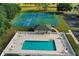 Aerial view of community amenities, including a sparkling pool, tennis courts, and a basketball court for active recreation at 10157 Spring Lake Dr, Clermont, FL 34711