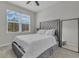 Cozy bedroom with a large window, plush gray carpeting, and a tufted headboard at 10157 Spring Lake Dr, Clermont, FL 34711