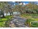 Scenic gated entrance to the property with mature trees and a glimpse of the waterfront at 10157 Spring Lake Dr, Clermont, FL 34711