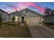 One-story home with gray siding, stone accents, and a two-car garage at 10157 Spring Lake Dr, Clermont, FL 34711