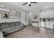 Comfortable living room featuring wood-look tile, a gray sofa, and a convenient kitchenette with mini-fridge at 10157 Spring Lake Dr, Clermont, FL 34711