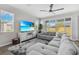 Bright living room with a gray sectional, large TV, and sliding glass doors to the outdoor area at 10157 Spring Lake Dr, Clermont, FL 34711