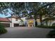 Elegant two-story home with a circular driveway and lush landscaping at 12540 Park Avenue, Windermere, FL 34786