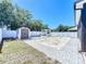 This large backyard has a shed, white fence, fire pit, and an attractive pergola at 1727 Wood Path, Auburndale, FL 33823