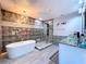 Luxurious bathroom featuring a soaking tub, glass-enclosed shower, and modern vanity with elegant lighting at 1727 Wood Path, Auburndale, FL 33823