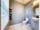 Cozy bathroom featuring modern vanity with round mirror, decorative shelving and updated tile flooring at 1727 Wood Path, Auburndale, FL 33823