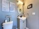 Cozy half-bathroom with modern vanity, oval mirror, and decorative wall art above the toilet at 1727 Wood Path, Auburndale, FL 33823