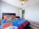 A bright guest bedroom features a ceiling fan, wood-look floors, and is near a spacious walk-in closet at 1727 Wood Path, Auburndale, FL 33823