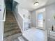 Welcoming foyer featuring tile flooring, a staircase with stone accents, and a glass-paneled front door at 1727 Wood Path, Auburndale, FL 33823