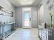 Bright foyer boasts white tiled floors, decorative console tables, and a glass-paneled front door, inviting guests at 1727 Wood Path, Auburndale, FL 33823