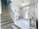 Inviting foyer with tile flooring, decorative tables, front door, and stairway creates a welcoming atmosphere at 1727 Wood Path, Auburndale, FL 33823