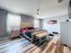 Main bedroom with wood-look floors, stylish furniture, ceiling fan, and natural light at 1727 Wood Path, Auburndale, FL 33823