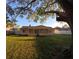 Spacious backyard with lush greenery, mature trees, and an enclosed patio with a door to the house at 1859 Lake Hill Cir, Orlando, FL 32818