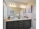 Bright bathroom with double vanity, modern fixtures, and a large mirror reflects the shower at 244 Villa Domani Cir, Davenport, FL 33896
