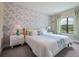 Bright bedroom features stylish floral wallpaper and matching bedding accents next to window at 244 Villa Domani Cir, Davenport, FL 33896