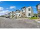 Street view of modern townhomes with sleek design, stone accents, and ample parking at 244 Villa Domani Cir, Davenport, FL 33896