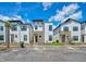 Modern townhome exterior featuring stone accents, white siding, and a well-maintained front yard at 244 Villa Domani Cir, Davenport, FL 33896