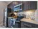 Modern kitchen featuring stainless steel appliances, stylish backsplash, and dark wood cabinets at 244 Villa Domani Cir, Davenport, FL 33896