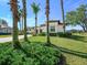 Home's exterior features a large lawn, palm trees, and a brick driveway at 25459 Hawks Run Ln, Sorrento, FL 32776