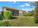 Well-maintained backyard featuring lush greenery and a charming screened-in porch at 440 Alcove Dr, Groveland, FL 34736
