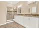 A modern bathroom with double vanity, granite countertops, and tiled walk-in shower with glass door at 440 Alcove Dr, Groveland, FL 34736