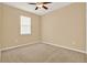 Neutral bedroom with plush carpet and a bright window, perfect for relaxation at 440 Alcove Dr, Groveland, FL 34736