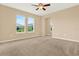 A cozy bedroom with carpet flooring, a ceiling fan, and abundant natural light through the windows at 440 Alcove Dr, Groveland, FL 34736