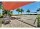 A shaded bocce ball court with seating for spectators on a sunny day at 440 Alcove Dr, Groveland, FL 34736