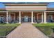 Clubhouse exterior boasts a covered entrance with grand columns and a brick walkway surrounded by greenery at 440 Alcove Dr, Groveland, FL 34736