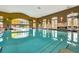Bright indoor pool area featuring palm trees and large arched windows that provide natural light at 440 Alcove Dr, Groveland, FL 34736