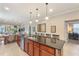 Open kitchen featuring a spacious island, stainless steel appliances, and modern lighting fixtures at 513 San Sebastian Ct, Davenport, FL 33837