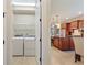 Open view of laundry room and kitchen with a stainless-steel appliances and wood cabinetry at 513 San Sebastian Ct, Davenport, FL 33837