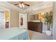 View of the main bedroom with a dresser, decor, tray ceiling, and access to the bathroom at 513 San Sebastian Ct, Davenport, FL 33837